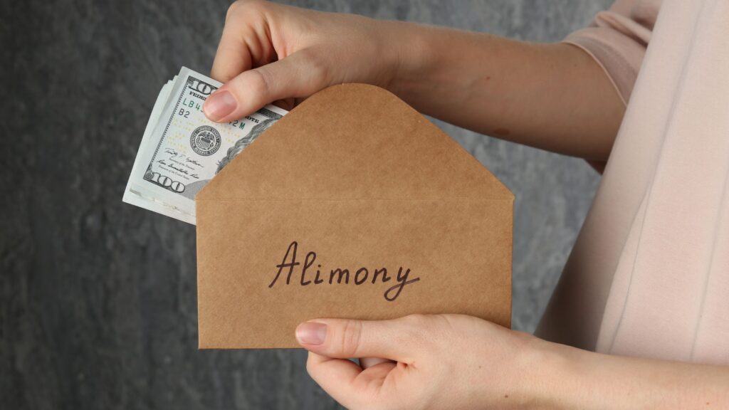 Hands holding an envelope labeled alimony, representing questions about how long does alimony last