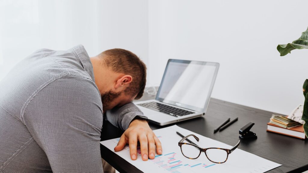 Man overwhelmed by financial decisions and pre retirement anxiety at his desk