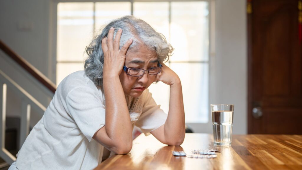 Older woman experiencing emotional distress during retirement transition.