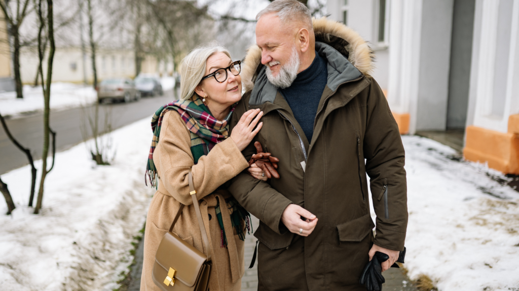 Older couple walking arm in arm outdoors representing aging in place and long-term care planning