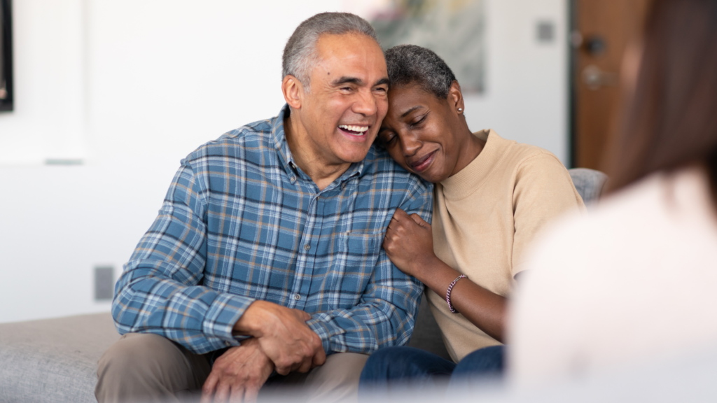 Couple laughing together during a retirement planning meeting with a fiduciary financial advisor